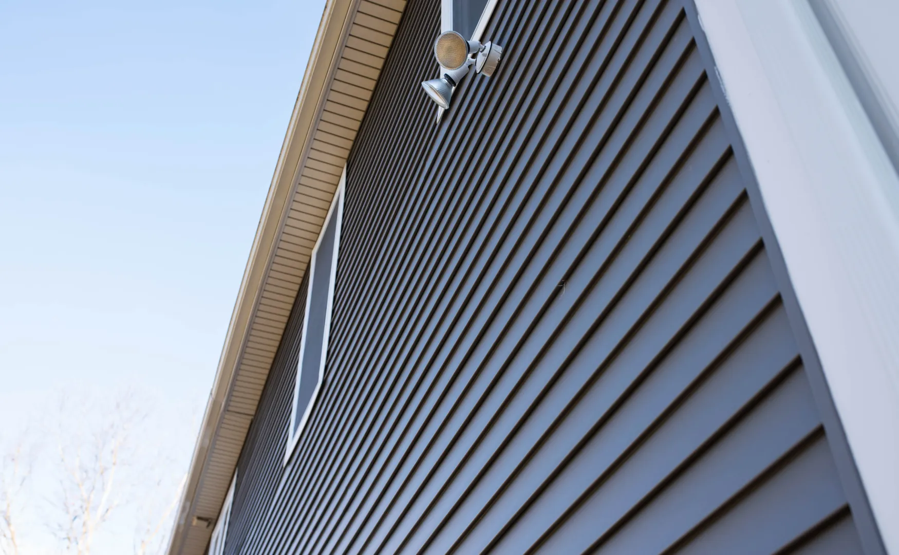 Gray aluminum siding installed horizontally on a house exterior